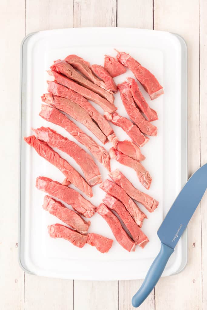 Place the steak between two pieces of plastic wrap and pound to -inch thickness. Cut the steak into strips.