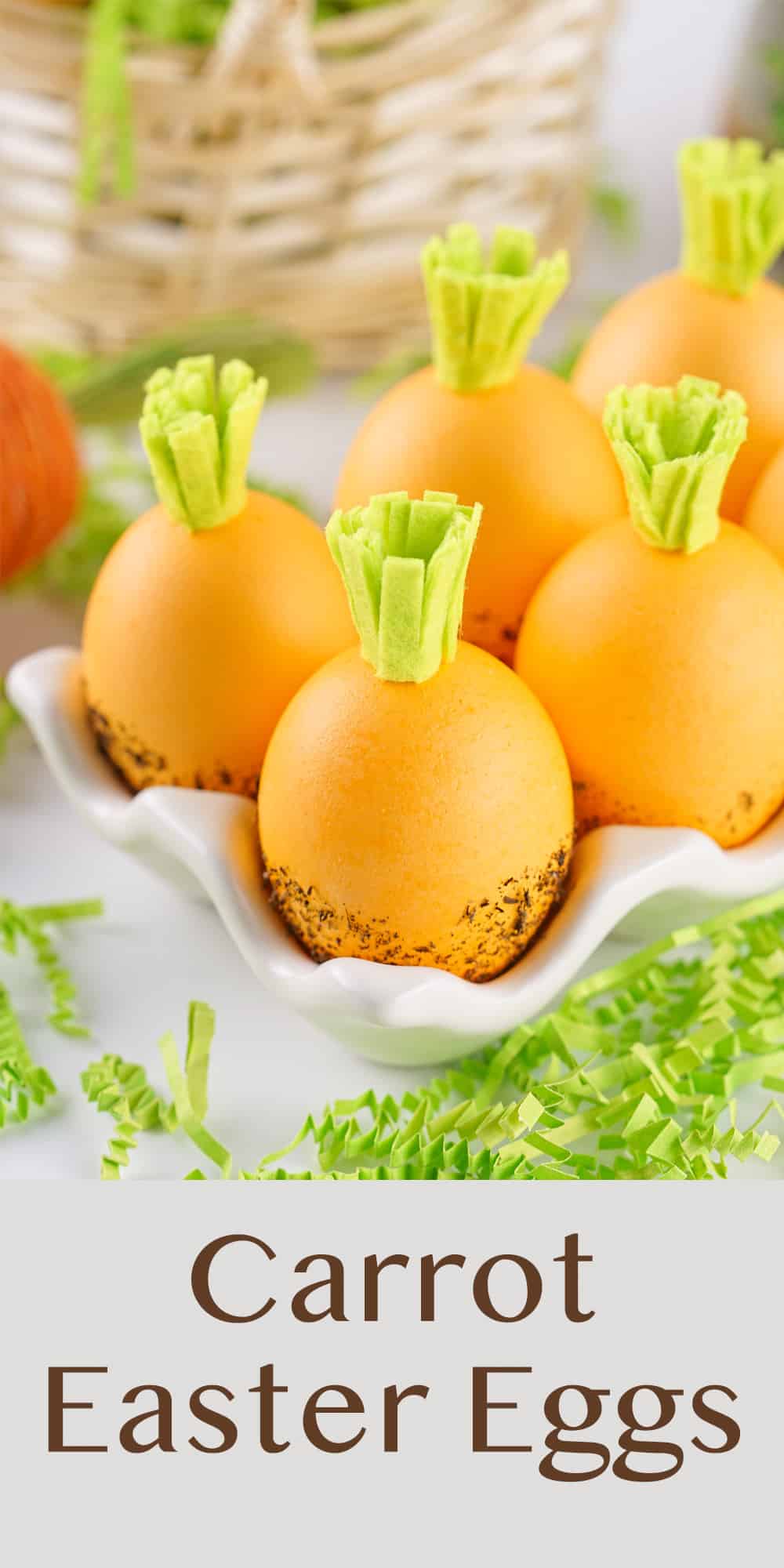 orange dyed Eater eggs with green flt top to look like carrots in a white egg holder with Easter decor around it.