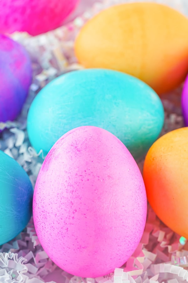 brightly colored Easter eggs on white paper shreds.