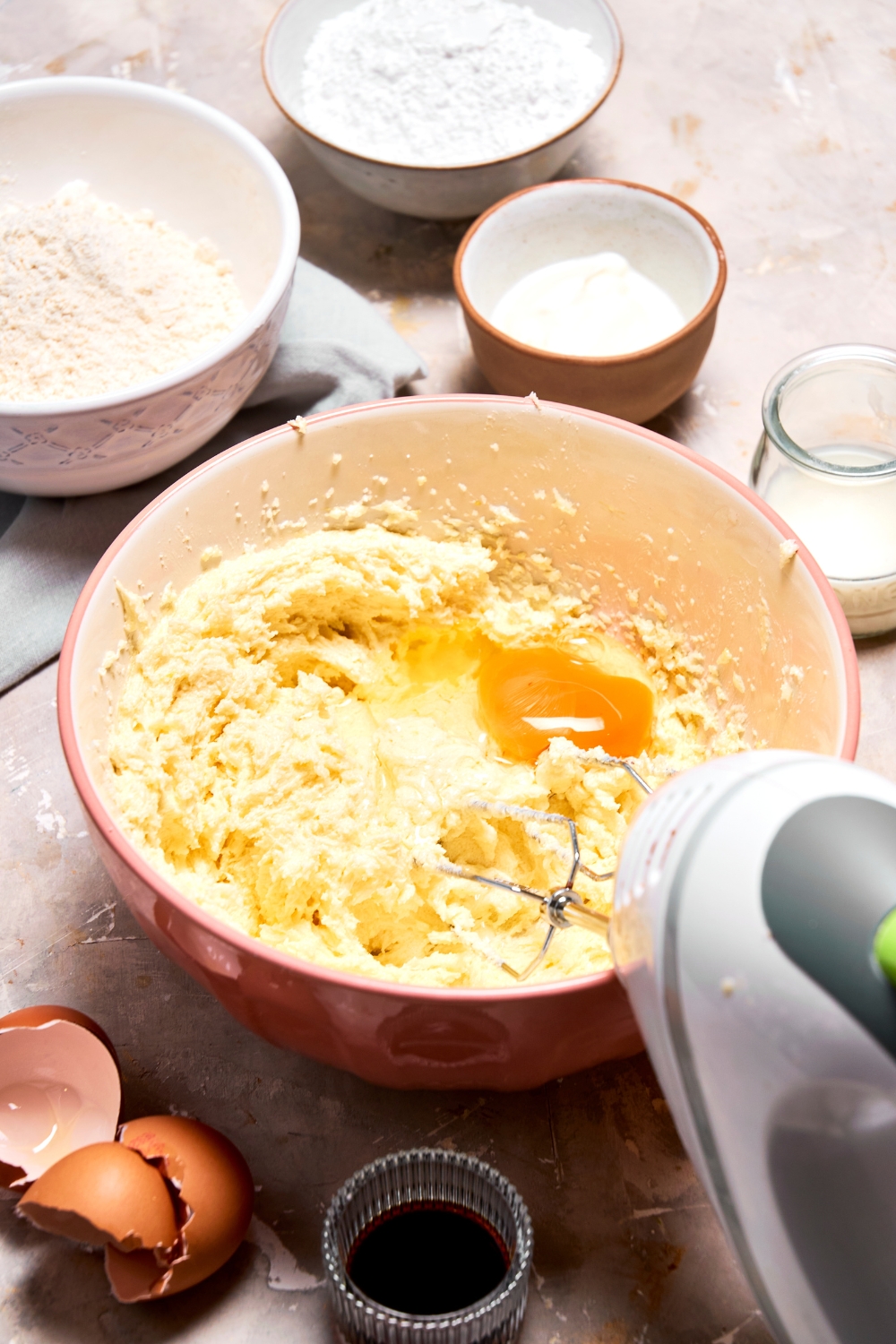 A mixing bowl with the creamed butter and an egg being beaten into it.