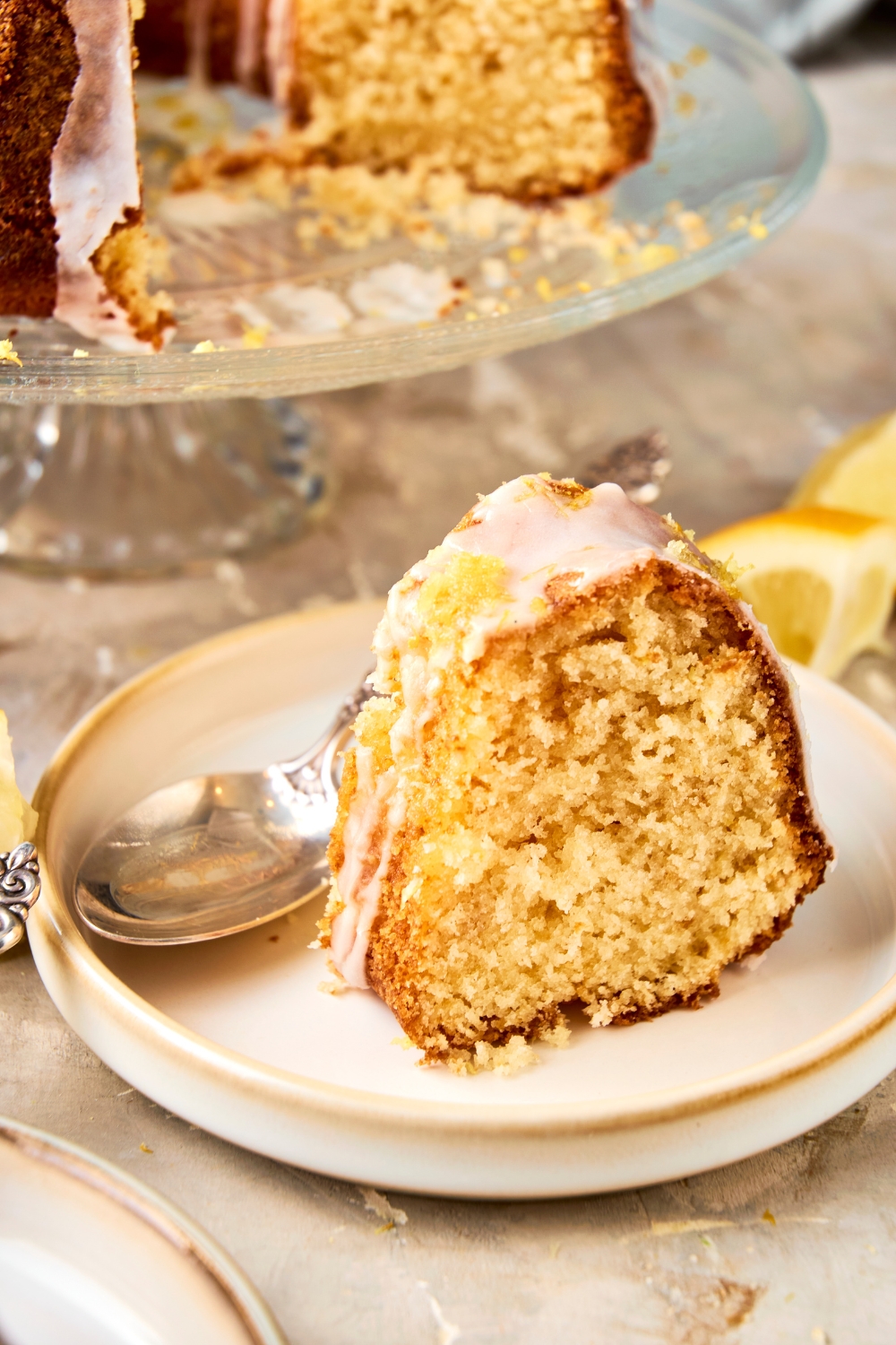 A small plate with a slice of lemon bundt cake with icing.