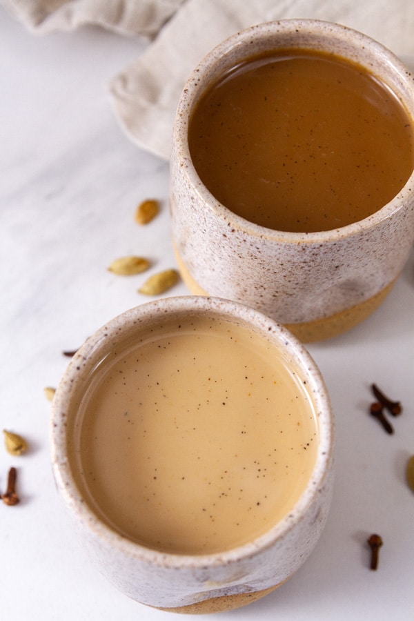 looking down into two mugs of chai made with different milks.